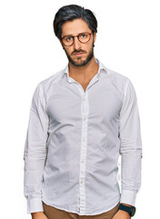 Young hispanic man wearing business shirt and glasses depressed and worry for distress, crying angry and afraid. sad expression.