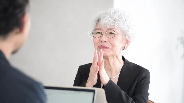 笑顔で打ち合わせするグレイヘアが素敵なシニア(高齢者)女性　営業などのビジネスシーンの動画