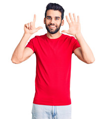 Fototapeta premium Young handsome man with beard wearing casual t-shirt showing and pointing up with fingers number seven while smiling confident and happy.