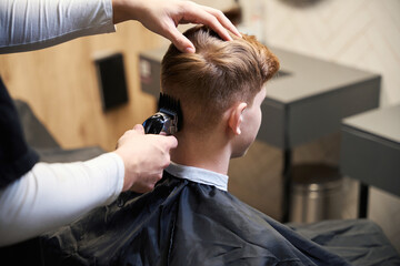 Fototapeta premium Skilled hairstylist working in contemporary hairdressing salon