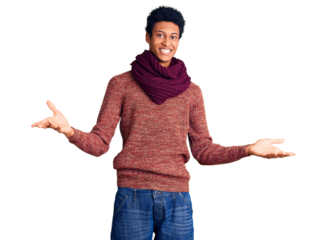 Young african american man wearing casual winter sweater and scarf smiling cheerful with open arms as friendly welcome, positive and confident greetings