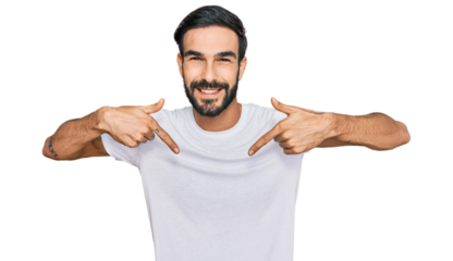 Young hispanic man wearing casual white t shirt looking confident with smile on face, pointing oneself with fingers proud and happy.