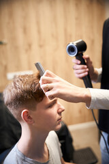 Experienced barber serving visitor in contemporary barbershop