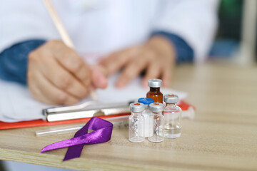 Purple Ribbon With Medical Bottle Against Blured Professional Doctor Background