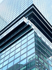 Corner Element Of Glass Modern Architecture Building With Reflection Of Blue Cloudy Sky Background During Bright Sunny Day