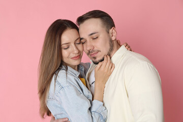 Happy couple hugging on pink background. Strong relationship