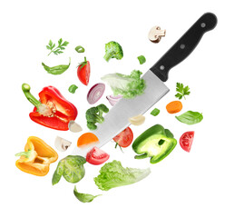 Knife cutting different vegetables in air on white background