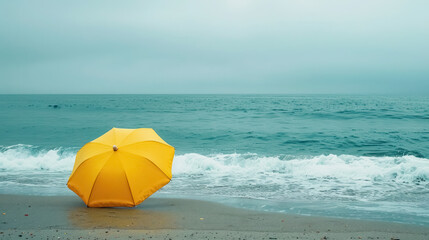solitary yellow umbrella on a misty beach with gentle waves