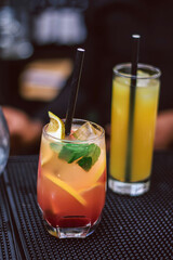 Cocktail with lime served in a Lagos bar - a glass of orange juice - mojito cocktail on a black background 