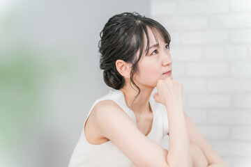 Fototapeta premium 頬杖をついて考える・悩む女性（美容・ダイエット） 