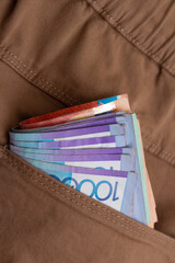 Vertical photo. Cash money of Kazakhstan. 10000 tenge. Kazakh paper banknote in pocket of brown denim jeans pants. Bank note. Concept of pay, salary, purchases, credit, tax, debt, salary, rich. Bill