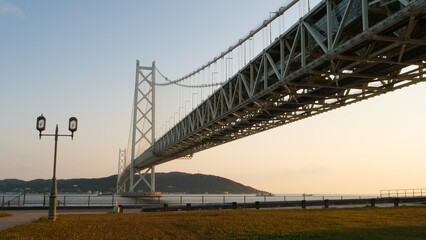 Obraz premium Akashi Kaikyo Bridge. Sunset view of ships passing by.