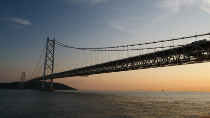 Akashi Kaikyo Bridge. Sunset view of ships passing by.