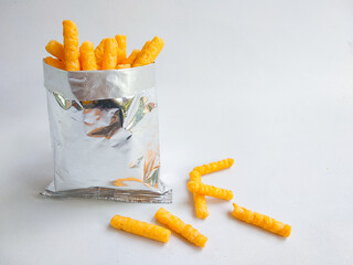 Cheese chips in open silver bag, isolated white background