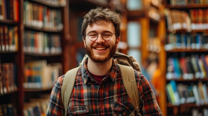 Fototapeta premium Handsome Smile student man with backpack and books in library, education, university, cheerful, college, happy, standing, school, backpack, attractive, enjoyment, confidence