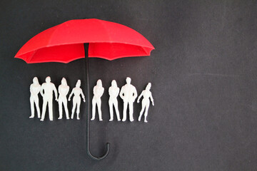 miniature people under an umbrella. the concept of life insurance. planning, saving families,...