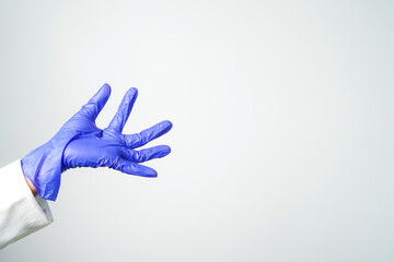 Doctor or nurse hand in sterile gloves in holding position isolated on white