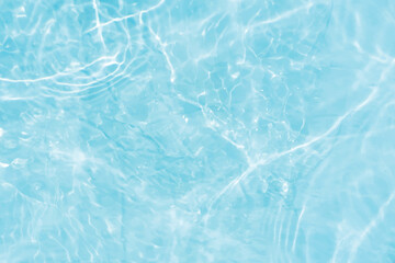Blue water with ripples on the surface. Defocus blurred transparent blue colored clear calm water surface texture with splashes and bubbles. Water waves with shining pattern texture background.