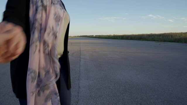 Mujer muy contenta tirando de la mano de su amigo  en una pista de aterrizaje porque se van de viaje en avi&oacute;n.