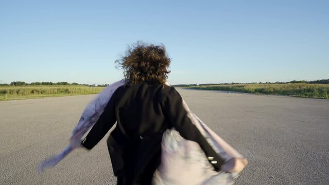 Mujer muy alegre moviendo los brazos y dando vueltas de alegr&iacute;a en una pista de aterrizaje.
