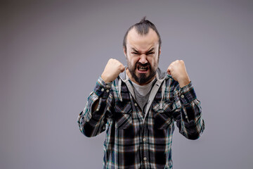 Aggressive man with beard showing fists is feeling angry
