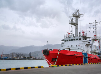 A red fire ship is moored to the pier. Close-up