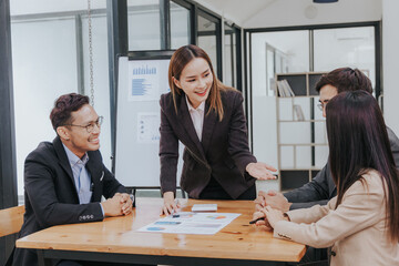 Professional team, including businessmen and businesswomen, engages in a strategy meeting. They discuss marketing, analyze financial data, and brainstorm investment plans using charts, graphs,