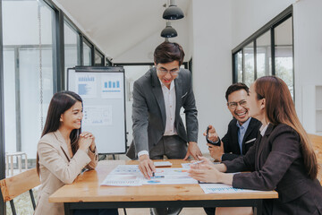 diverse team of professionals, including men and women, engages in a lively discussion. They brainstorm marketing strategies, analyze finance reports, and plan investments for their startup.