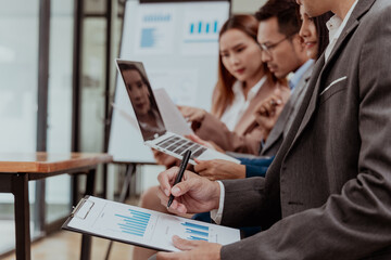 diverse team of professionals, including men and women, engages in a lively discussion. They brainstorm marketing strategies, analyze finance reports, and plan investments for their startup.