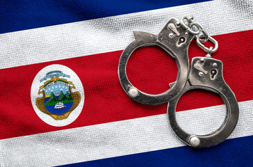 Flag of Costa Rica and police handcuffs. Crime and offenses in country Concept
