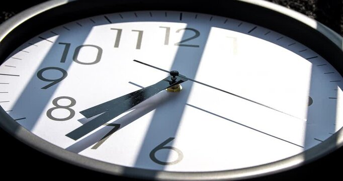 Sun and sky reflecting in the watch during the time passing by. Time lapse on a modern white Clock on black. Close up to a wall clock, with running time pointer. Wall clock show the running time. 