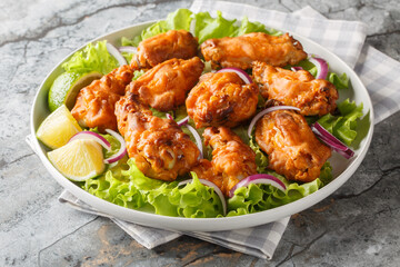 Asian style fried chicken is marinated with Tom Yam paste and then deep-fried to perfection closeup on the plate on the table. Horizontal