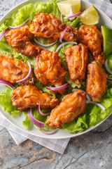 Fried Tom Yam Chicken is an Asian inspired Thai Style deep fried dish closeup on the plate on the table. Vertical top view from above