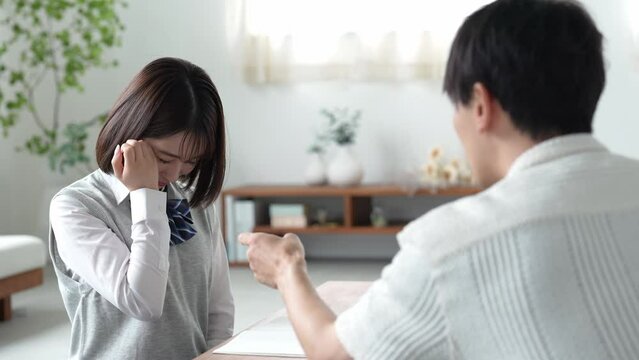 自宅で叱られる女子高生