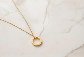 Fototapeta premium A gold necklace with a small circular pendant on a white stone background