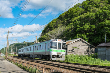 Fototapeta premium 日本海に向かって切り立った崖の淵を走る列車
