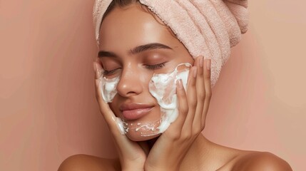 Serene beauty applying facial cream on a soft pink background