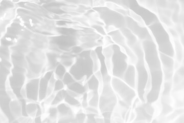 White water with ripples on the surface. Defocus blurred transparent white colored clear calm water surface texture with splashes and bubbles. Water waves with shining pattern texture background.