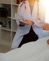Young doctor is using a stethoscope listen to the heartbeat of the patient. Shot of a female doctor...