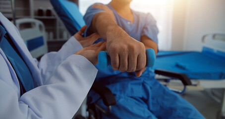 Physiotherapist man giving exercise with dumbbell treatment About Arm and Shoulder of athlete male patient Physical therapy concept