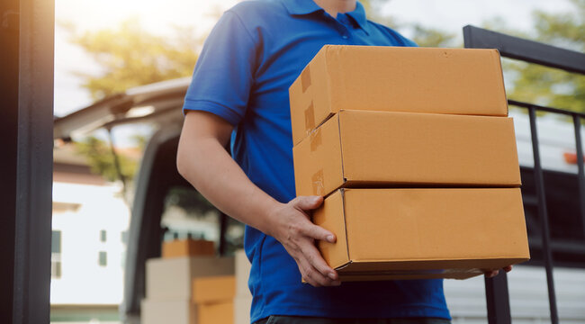 Asian delivery express courier young man use giving boxes to woman customer he wearing protective face mask at front home