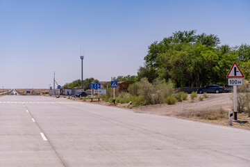 A road with a sign that says 100m ahead. The road is empty and there are no cars