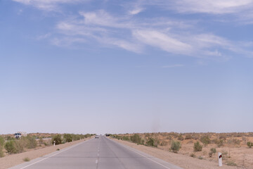 A road with a few cars on it and a clear blue sky