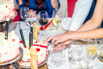 A couple is cutting a cake with candles on it