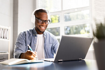 Focused Black Man Utilizing Digital Tools for Online Education