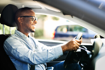 Successful African American CEO happily driving new corporate car in summer
