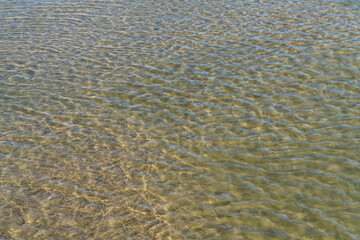 Clear water in a river, lake, or estuary. Natural water with a small waves textured background. 