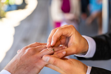 Fototapeta premium A man is getting his ring put on by another man