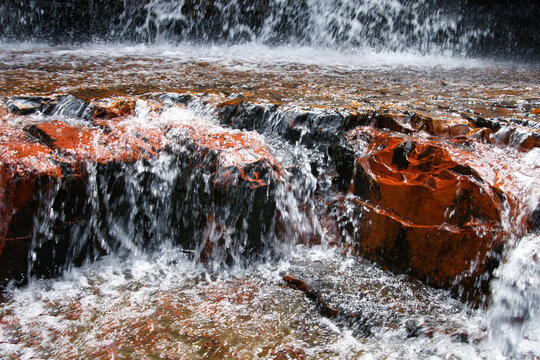Red jasper gemstone riverbed with the waterfall of Jasper Creek, Quebrada de Jaspe, Gran Sabana, Venezuela