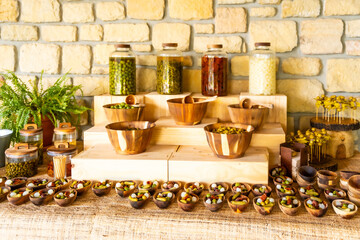 A table with many bowls of food and a few potted plants